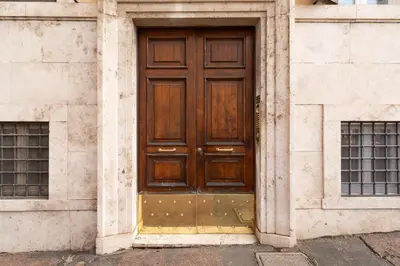 a wooden door in a building with two windows at Pearl of Circo Massimo in Rome