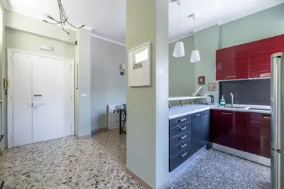 a kitchen with red cabinets and a sink at Casa Preziosa in Metro Piramide in Rome