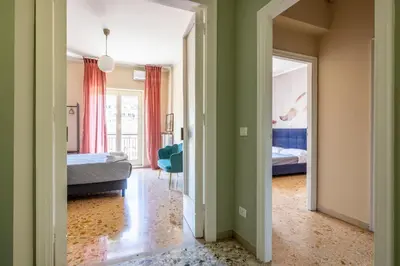 a room with two beds and a bedroom with green walls at Casa Preziosa in Metro Piramide in Rome