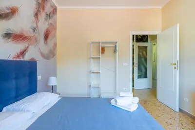 a bedroom with a blue bed with a painting on the wall at Casa Preziosa in Metro Piramide in Rome
