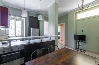 a kitchen with a wooden table and a dining room at Casa Preziosa in Metro Piramide in Rome