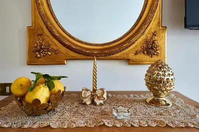 a table with a mirror and a bowl of fruit at La Perla di Trevi in Rome