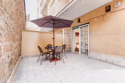 a table and chairs with an umbrella on a patio at Aventino Industrial Loft in Rome