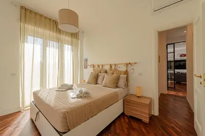 a bedroom with a large bed and a large window at Bright and cozy apartment near the Vatican city in Rome