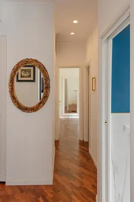 a hallway with a round mirror on a wall at Bright and cozy apartment near the Vatican city in Rome