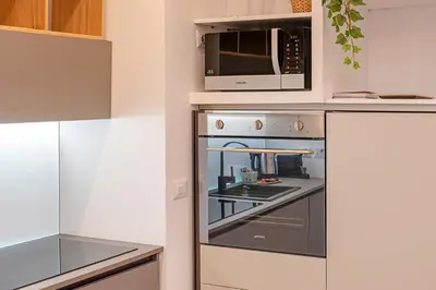 a kitchen with an oven with a microwave above it at Bright and cozy apartment near the Vatican city in Rome