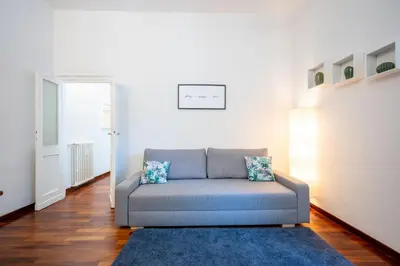 a couch in a living room with a blue rug at Elegante Appartamento con Giardino, Vicino al Centro di Roma e Stadio Olimpico in Rome