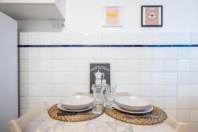 a table with two plates and wine glasses on it at Elegante Appartamento con Giardino, Vicino al Centro di Roma e Stadio Olimpico in Rome