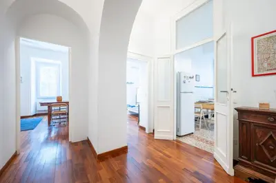 a living room with a wooden floor and white walls at Elegante Appartamento con Giardino, Vicino al Centro di Roma e Stadio Olimpico in Rome
