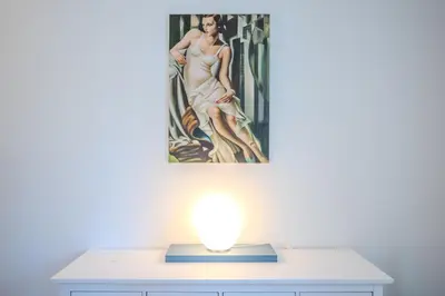 a lamp on a desk with a painting on the wall at Elegante Appartamento con Giardino, Vicino al Centro di Roma e Stadio Olimpico in Rome