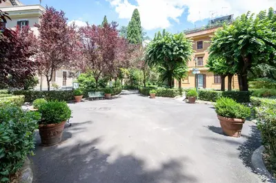 a courtyard with potted plants and a building at Elegante Appartamento con Giardino, Vicino al Centro di Roma e Stadio Olimpico in Rome