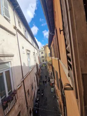 an alley between two buildings with people walking down it at Home Bella Roma centro storico in Rome
