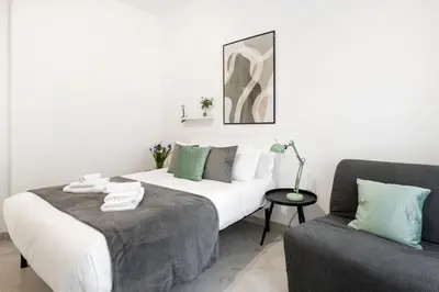 a bedroom with a large bed and a chair at White Flat San Lorenzo in Rome