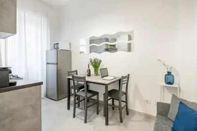 a kitchen with a table with chairs and a refrigerator at White Flat San Lorenzo in Rome