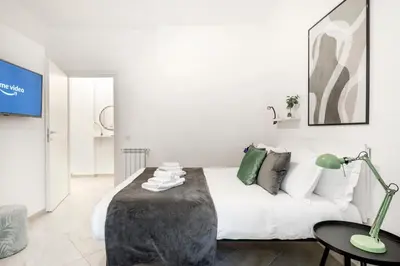 a white bedroom with a white couch and a table at White Flat San Lorenzo in Rome