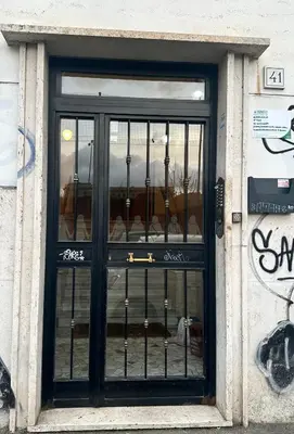 a door of a store with wrought iron gate at White Flat San Lorenzo in Rome