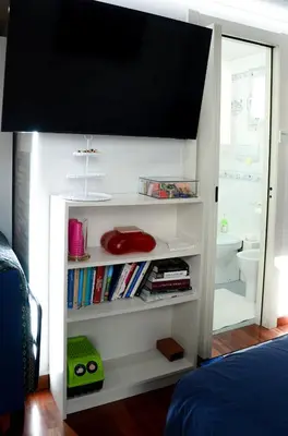 a bedroom with a book shelf with a television on it at Magnifico 122 Apartment in Rome