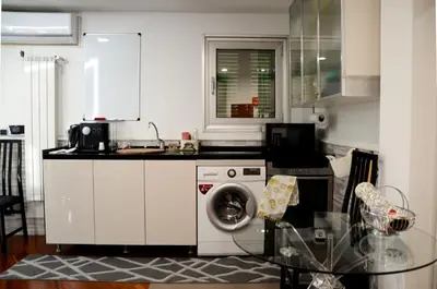 a kitchen with a washing machine and a glass table at Magnifico 122 Apartment in Rome
