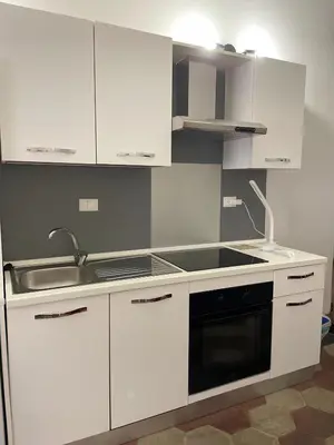 a kitchen with white cabinets and a sink and a stove at Ale home in Rome