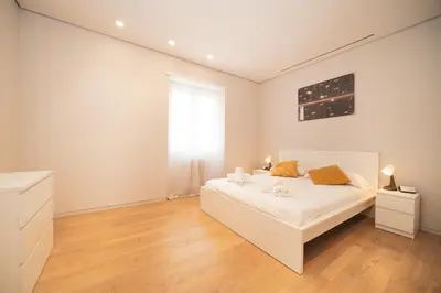 a white bedroom with a bed and a window at Green Hill Buddyrent's in Rome