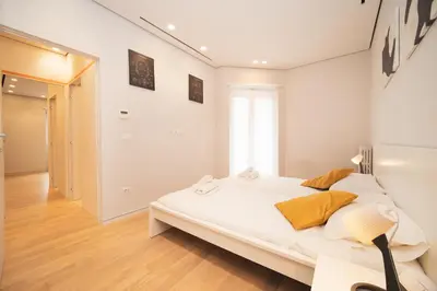 a white bedroom with a bed and a hallway at Green Hill Buddyrent's in Rome