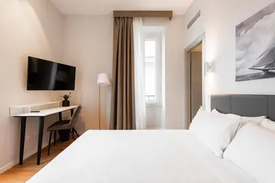 a hotel room with a white bed and a desk at Major House - Luxury Apartments in Rome by Hostand in Rome