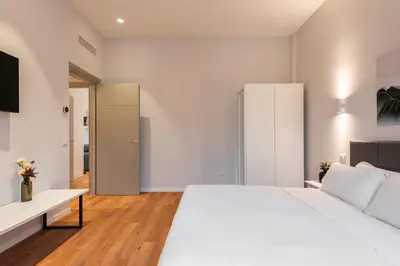 a bedroom with a white bed and a white cabinet at Major House - Luxury Apartments in Rome by Hostand in Rome