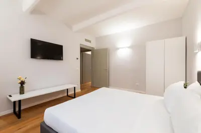a white bedroom with a bed and a tv at Major House - Luxury Apartments in Rome by Hostand in Rome