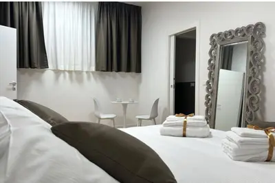 a bedroom with a bed with a mirror and a table at Cola di Rienzo 243 Relais-B in Rome