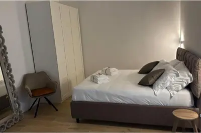 a bedroom with a bed with a chair and a mirror at Cola di Rienzo 243 Relais-B in Rome