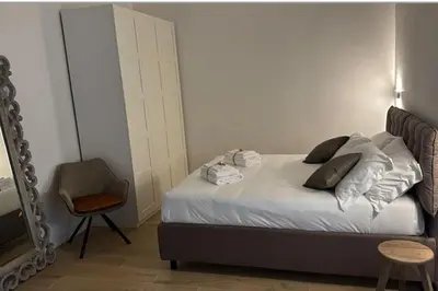 a bedroom with a bed with a mirror and a chair at Cola di Rienzo 243 Relais-B in Rome