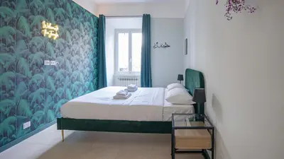 a bedroom with a bed with a blue and green wallpaper at EasyTopStay - Crescenzio Stylish Apartment in Rome