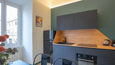 a kitchen with a refrigerator and a table and chairs at EasyTopStay - Crescenzio Stylish Apartment in Rome