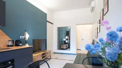 a living room with a tv and a table with blue flowers at EasyTopStay - Crescenzio Stylish Apartment in Rome