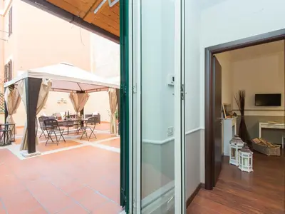 an open door to a patio with a table and umbrella at Apartment Vatican - Residenza Argilla by Interhome in Rome