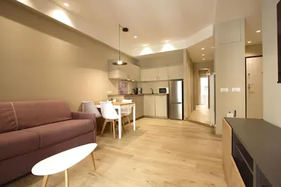 a living room and kitchen with a couch and a table at Aniene Holiday House in Rome