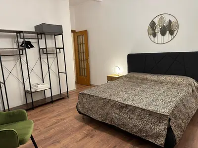 a bedroom with a bed and a green chair at luna in trastevere apartamento in Rome