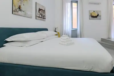 a bed with white sheets and pillows in a bedroom at Restart Accommodations Trevi in Rome