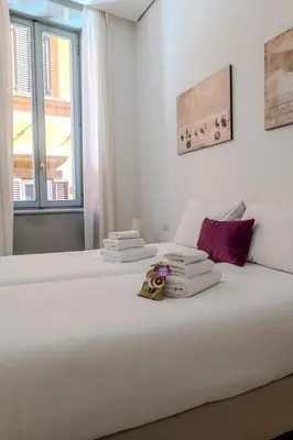 a bedroom with a white bed with towels on it at Restart Accommodations Trevi in Rome