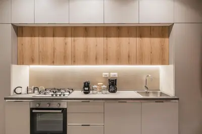 a kitchen with white cabinets and a stove and a sink at The Best in Rome Orologio in Rome