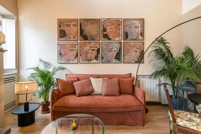 a living room with a couch and two plants at Attico le Stelle de Roma in Rome