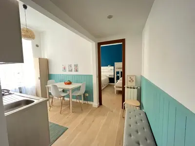 a kitchen and living room with a table and chairs at Casa Latina in Rome