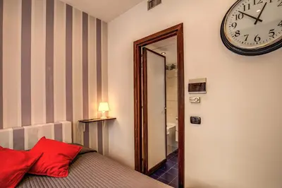 a bedroom with a mirror and a clock on the wall at M&L Apartments - Ardesia Colosseo in Rome