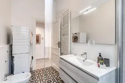 a white bathroom with a sink and a toilet at Supernova Apartment Trastevere in Rome