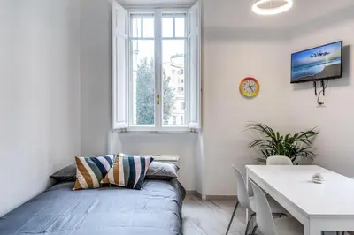 a bedroom with a bed and a table and a window at Supernova Apartment Trastevere in Rome