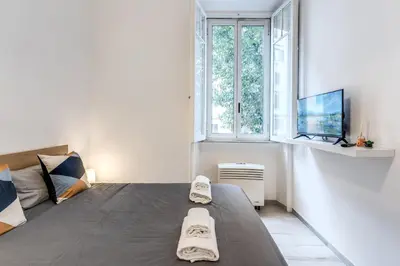 a bedroom with a bed and a tv and a window at Supernova Apartment Trastevere in Rome