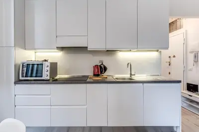 a white kitchen with a sink and a microwave at Supernova Apartment Trastevere in Rome