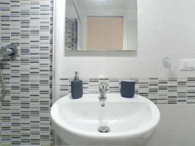 a white sink in a bathroom with a mirror at Movie Apartment in Rome
