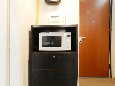 a microwave sitting on top of a black cabinet at Movie Apartment in Rome