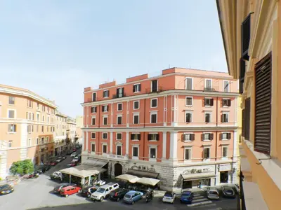 a large building with cars parked in a parking lot at Movie Apartment in Rome